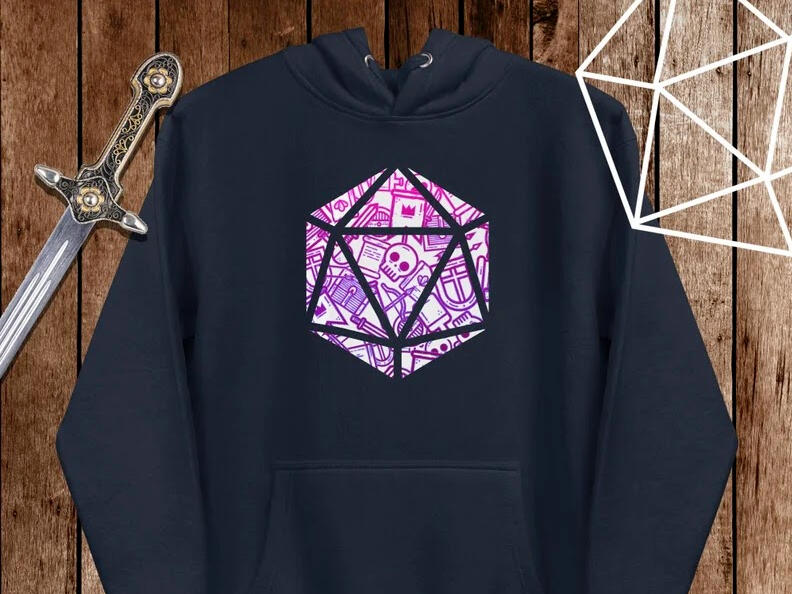 An image of a Lucky Fox Studio designed hoodie with the shape of a D20 inlayed with skulls, bow and arrow, chest, and other adventuring items.