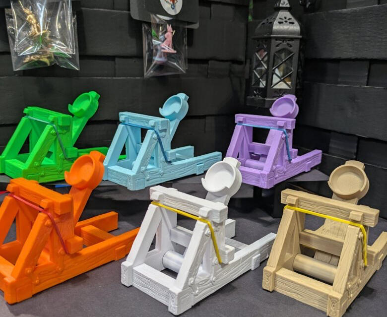 An image of several 3D-printed dice catapults made by Lucky Fox Studio